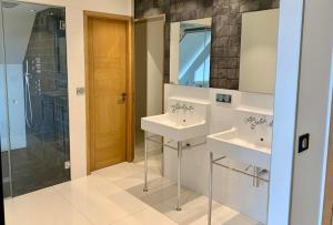 a bathroom with two sinks and a shower at Suite dans villa moderne avec piscine in Arradon