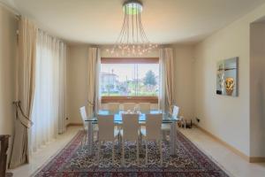 comedor con mesa, sillas y lámpara de araña en Villa Vescovado casa vacanza en Brusaporto