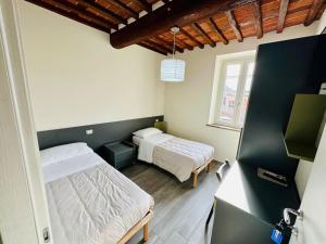 sypialnia z 2 łóżkami i oknem w obiekcie Locazione Turistica Rania w mieście Capannori