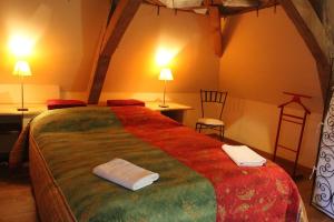 a bedroom with a large bed with two towels on it at La Cuvellerie in Narcy