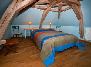 a bedroom with a bed and a table and two chairs at La Cuvellerie in Narcy