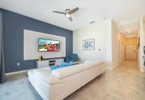 uma sala de estar com um sofá branco e uma parede azul em 3180-405DC STOREY LAKE, CONDO 2/2 POOL VIEW em Kissimmee