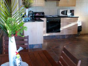 a kitchen with a stove and a table with chairs at Belcharto Accommodation in Stellenbosch