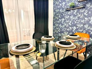 a glass table with plates and glasses on it at Rooms Near Me - Worcester, Sky Tv, Free Double Parking in Worcester