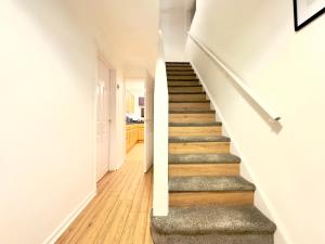 una escalera en una casa con paredes blancas y suelo de madera en Rooms Near Me - Worcester, Sky Tv, Free Double Parking, en Worcester