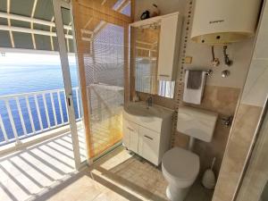 a bathroom with a toilet and a sink with a balcony at Kate's Place in Dubrovnik