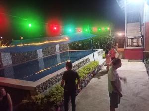um grupo de pessoas de pé perto de uma piscina à noite em Balay Jardin Murcia 