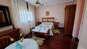 a bedroom with a bed and a table in a room at La Madre Abadesa, Casa en Casco Historico in Tordesillas
