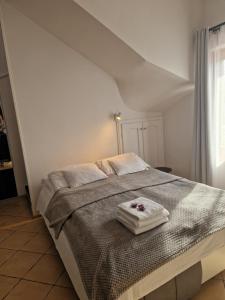 een slaapkamer met een bed met twee handdoeken erop bij Martina apartman in Gyula +32 foto's
