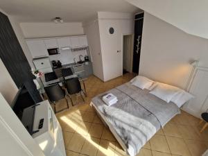 a bedroom with a bed and a kitchen at Martina apartman in Gyula
