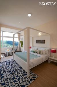 a bedroom with a canopy bed with a blue rug at EKOSTAY I Pearl House Villa I 360 Degrees Tea Estate in Ooty