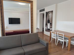 sala de estar con sofá, mesa y espejo en Hotel Madl en Velké Bílovice
