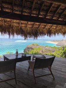 a patio with a table and chairs and the ocean at Bo'a Vida Rote in Nembrala