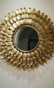 un espejo de oro con una corona de laurel alrededor en Elania Residence, en Târgu Jiu