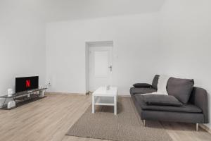 a living room with a couch and a tv at City Center Suite - Modern & Stylish in Bratislava