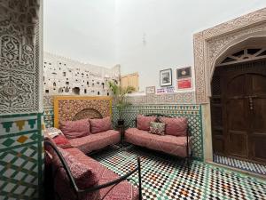 une chambre avec deux chaises roses et une porte dans l'établissement Dar Sunrise Fes, à Fès