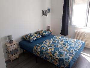 a bedroom with a bed with a blue comforter at L'INSO GAMBETTA in Chambéry
