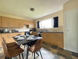 uma cozinha com uma mesa e cadeiras numa cozinha em Stunning 3 bedrooms house with Garden and Free Parking em Barnsley