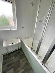 uma casa de banho com uma banheira, um lavatório e um chuveiro em Stunning 3 bedrooms house with Garden and Free Parking em Barnsley