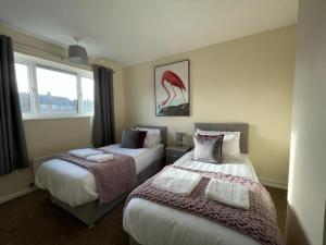 En eller flere senge i et værelse på Stunning 3 bedrooms house with Garden and Free Parking
