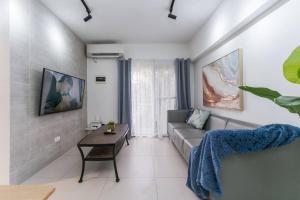 a living room with a couch and a table at AIRPORT EXPRESS HOSTEL E-527, 3 Minutes to Airport, Fast Wi-fi, Free Netflix in Pusok