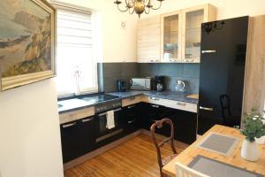 eine Küche mit schwarzen Schränken und einem Holztisch in der Unterkunft Ferienwohnung Coco Brockesstr. 10 in Lübeck