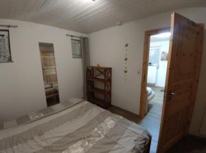 um quarto com uma cama e uma porta aberta em Ferienwohnungen Seereif im Erdgeschoss und Seeklein im Souterrain em Immenstaad am Bodensee
