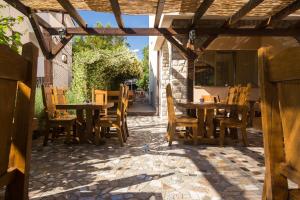 an outdoor patio with wooden tables and chairs at Bed & Breakfast Mario in Krk