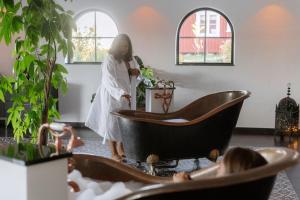 a woman standing next to a tub in a room at Ulvsby Herrgård in Sunne