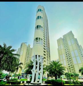 a tall white building with a statue in front of it at Palm Studio & looms in Noida