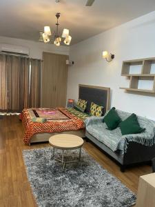 a living room with two beds and a couch at Palm Studio & looms in Noida