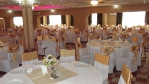 une salle de banquet avec des tables et des chaises blanches dans une pièce dans l'établissement Motel Moara Veche, à Săcălăşeni 72 autres photos
