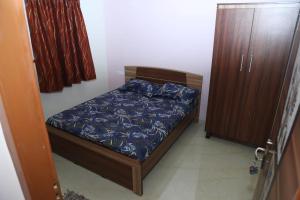 a small bedroom with a bed and a cabinet at PARADISE BANQUET HALL & A/C ROOMS in Madurai