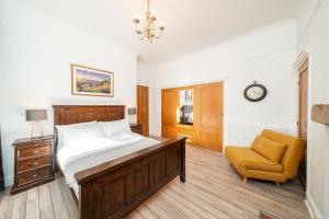 a bedroom with a bed and a chair and a clock at Desswood Aberdeen City Centre Apartment in Aberdeen