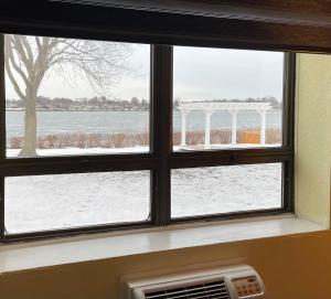 una ventana con vistas a un campo cubierto de nieve en Lakeside Inn, en Wakefield