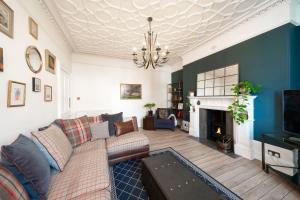 a living room with a couch and a fireplace at Desswood Aberdeen City Centre Apartment in Aberdeen