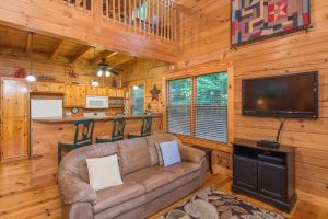 un soggiorno con divano e TV a schermo piatto di Firefly Lodge Private Log Cabin with Mountain Views! a Black Mountain