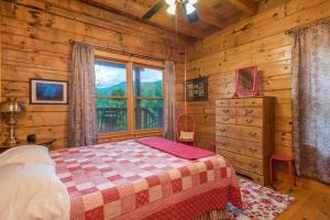 una camera con letto e finestra in una baita di tronchi di Firefly Lodge Private Log Cabin with Mountain Views! a Black Mountain