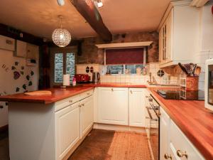 eine Küche mit weißen Schränken und Arbeitsflächen aus Holz in der Unterkunft Quirky in Chipping in Preston