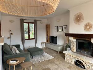 uma sala de estar com um sofá e uma lareira em Villa 4-6 pers Luberon Côté Oliviers em Gargas