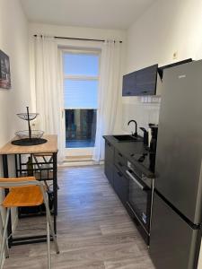 een keuken met een koelkast, een tafel en een raam bij Apartment „Babylon“ in Leipzig