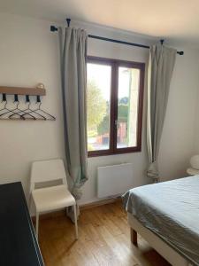um quarto com uma cama, uma janela e uma cadeira em Villa 4-6 pers Luberon Côté Oliviers em Gargas