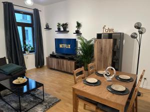 een woonkamer met een tafel en een televisie bij Apartment „Babylon“ in Leipzig