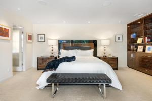 um quarto com uma grande cama branca e um banco em 17 Palms em Palm Springs