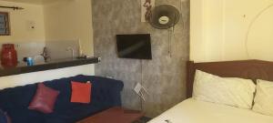 Tamara One Bedroom Apartment in Shanzu في مومباسا: غرفة نوم بسرير ومغسلة وتلفزيون