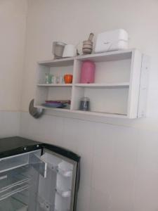 a white shelf on a wall with items on it at Tamara One Bedroom Apartment in Shanzu in Mombasa +6 photos