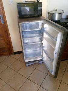 - un réfrigérateur avec une porte ouverte dans la cuisine dans l'établissement Tamara One Bedroom Apartment in Shanzu, à Mombasa