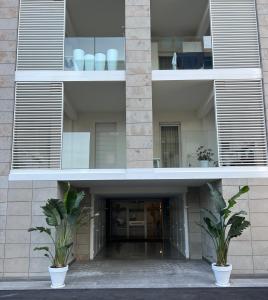 an external view of a building with two potted plants at Casa degli Ori by the city in Prato