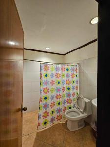 a bathroom with a shower curtain with a toilet at Beach Side Room The Beach Park-Hadsan in Lapu Lapu City