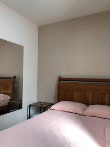 a bedroom with a bed with pink sheets and a mirror at Sítio Exclusivo em Marechal Floriano, Piscina, Sauna, Jacuzzi e Lago - Estrada Calçada a 200 metros da Rua Principal in Marechal Floriano